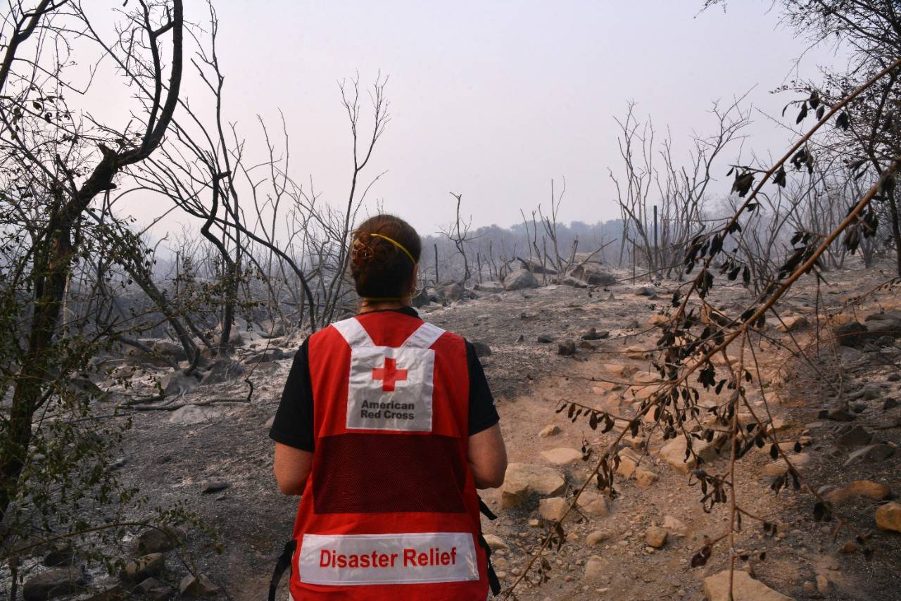 December 8, 2017. Ventura, California.
Thick smokes chokes out the sun as disaster volunteer Vicki Eichstaedt walks near burned out areas of the Los Padres National Forest. The hiking trails here are very popular and will be missed until they are able to be reopened to the public.
Photo by: Dermot Tatlow/American Red Cross
